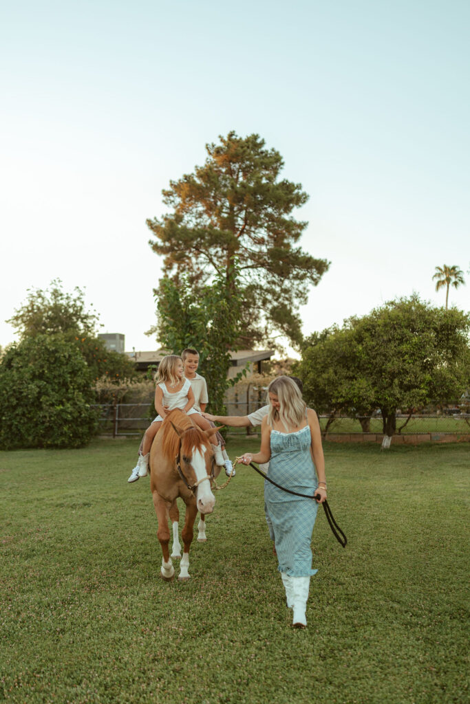 Horse lover maternity photos capturing an expecting mom leading her children on horseback during a family session at Floyd Family Farms.