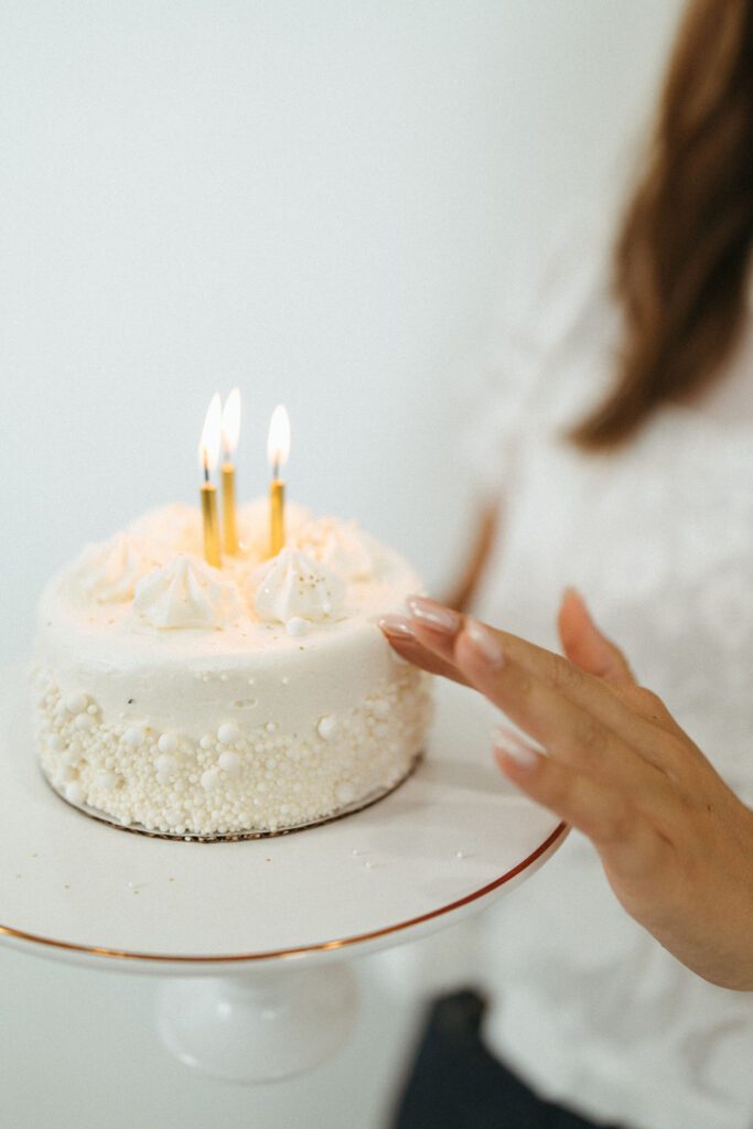 Close-up of a white birthday cake with lit candles during an 18th birthday studio photography session.