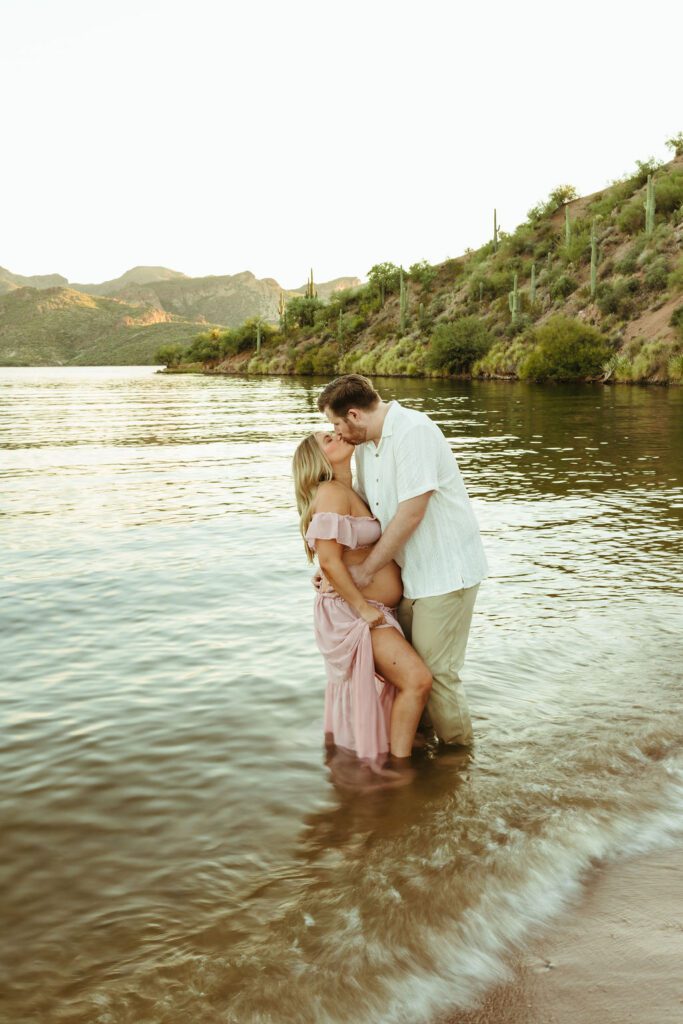 Expecting couple embracing in Saguaro Lake during their romantic Butcher Jones maternity photos in Mesa, Arizona