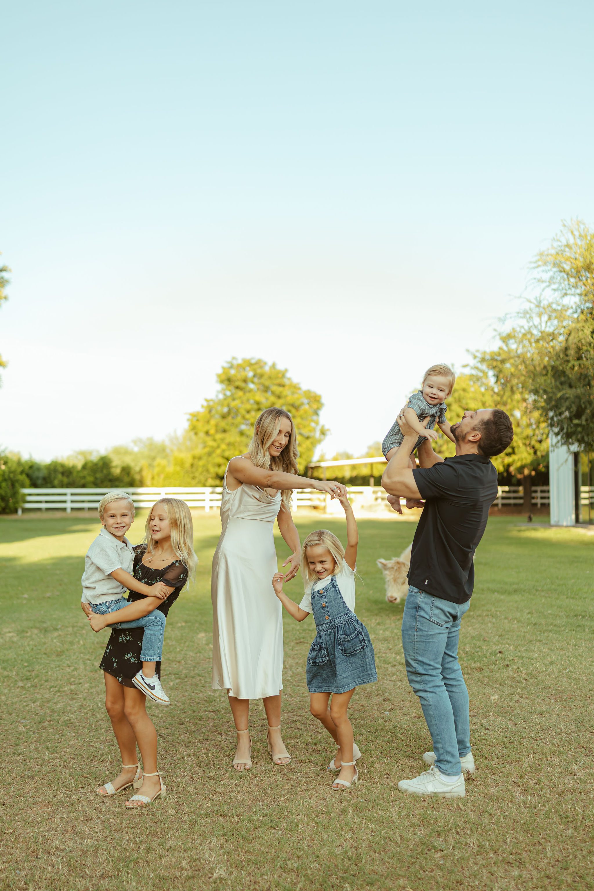 Phoenix family photographer capturing a candid, playful moment of a family of seven dancing together at an outdoor golden hour lifestyle session.