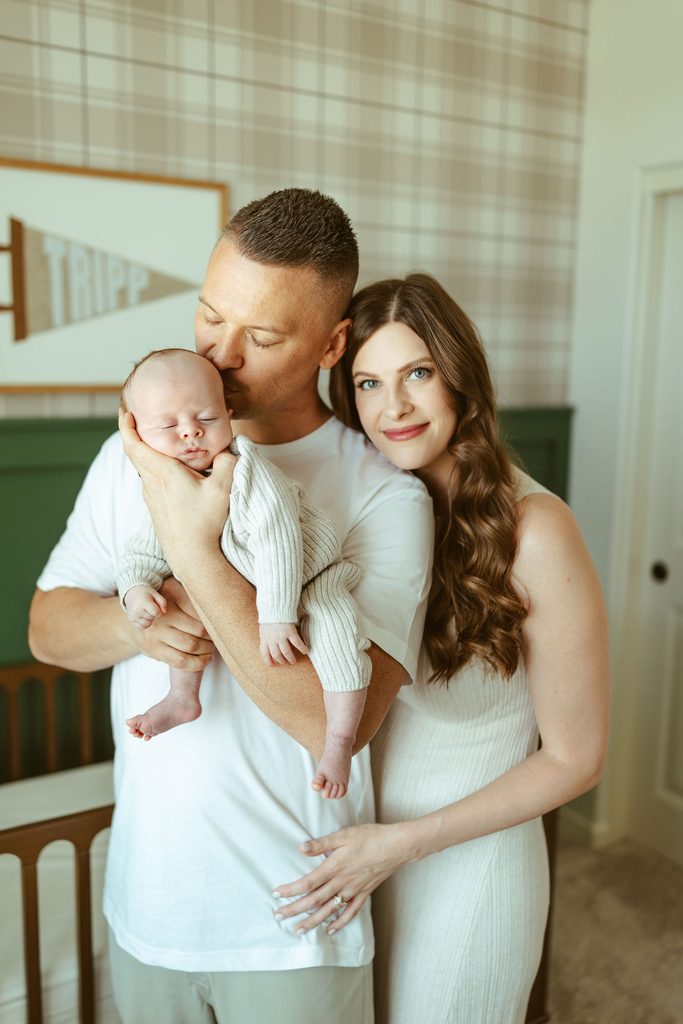 Gilbert newborn photographer capturing parents cuddling their newborn baby together in their beautiful Gilbert, Arizona home during an in-home lifestyle newborn session.