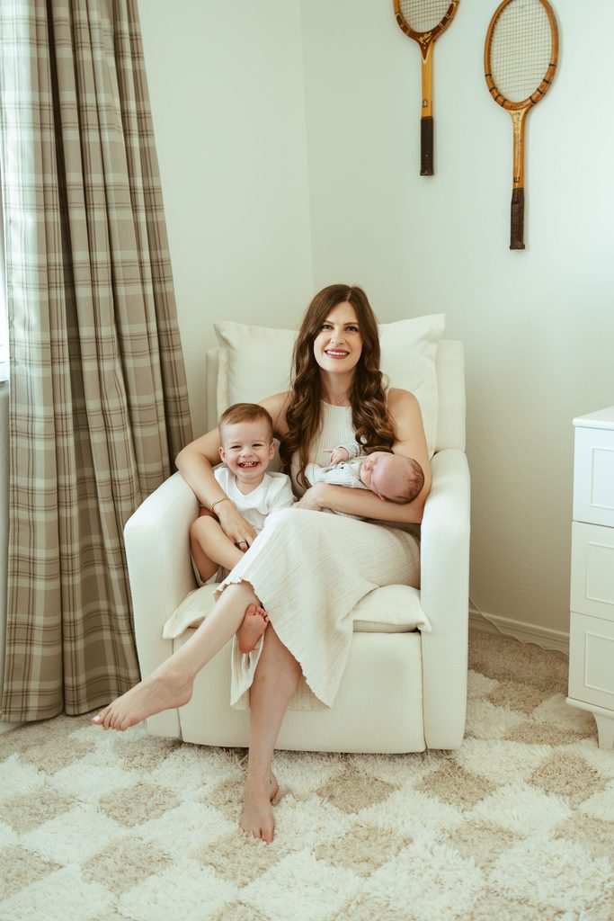 Gilbert family and newborn photography featuring a mother cuddling her newborn baby in a cozy nursery chair during an in-home session.