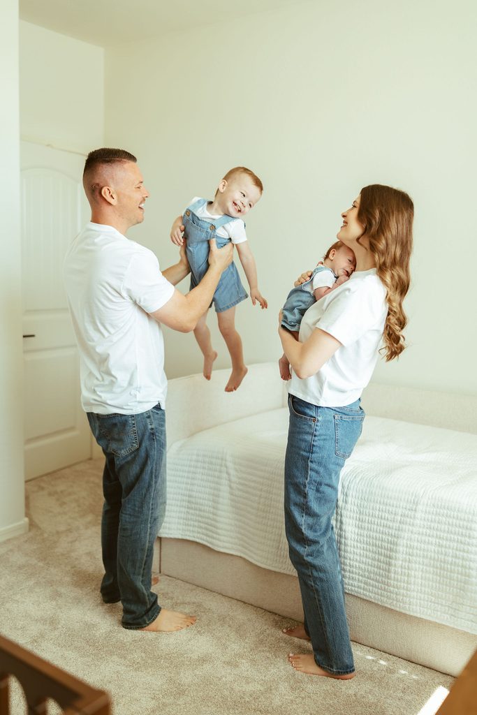 Gilbert family newborn photography capturing parents playing with their toddler and newborn together in the nursery during an in-home session.