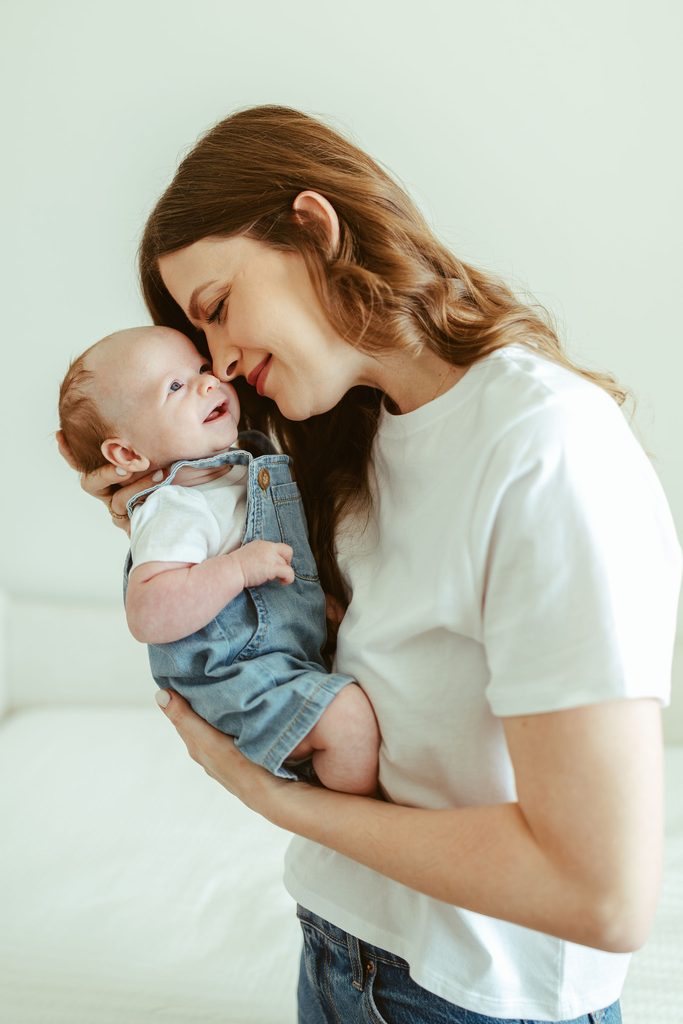 Gilbert newborn photographer capturing a tender moment between a mother and her newborn baby during a natural in-home newborn session in Gilbert, Arizona.