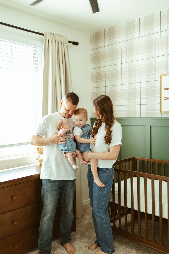 Gilbert newborn photography featuring a newborn baby lying in the nursery beside a personalized framed sign during an in-home session.