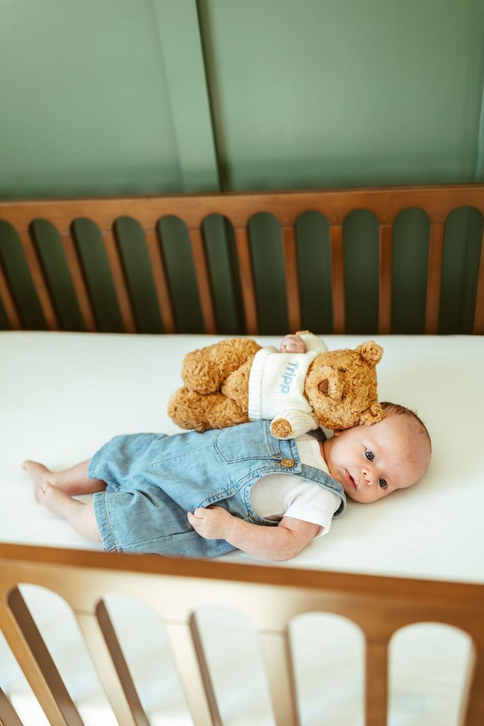 Gilbert newborn photographer capturing newborn siblings lying together on a bed during a beautiful in-home newborn session in Gilbert, Arizona.