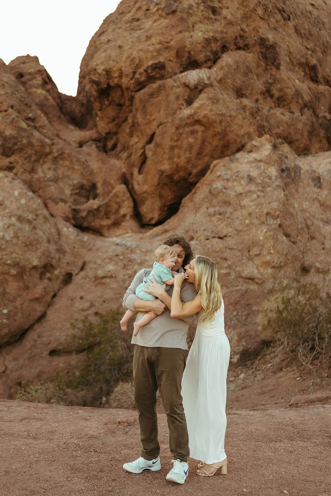 Scottsdale family photographer capturing tight, emotional family snuggles tucked into the sandstone rock formations at Papago Park.