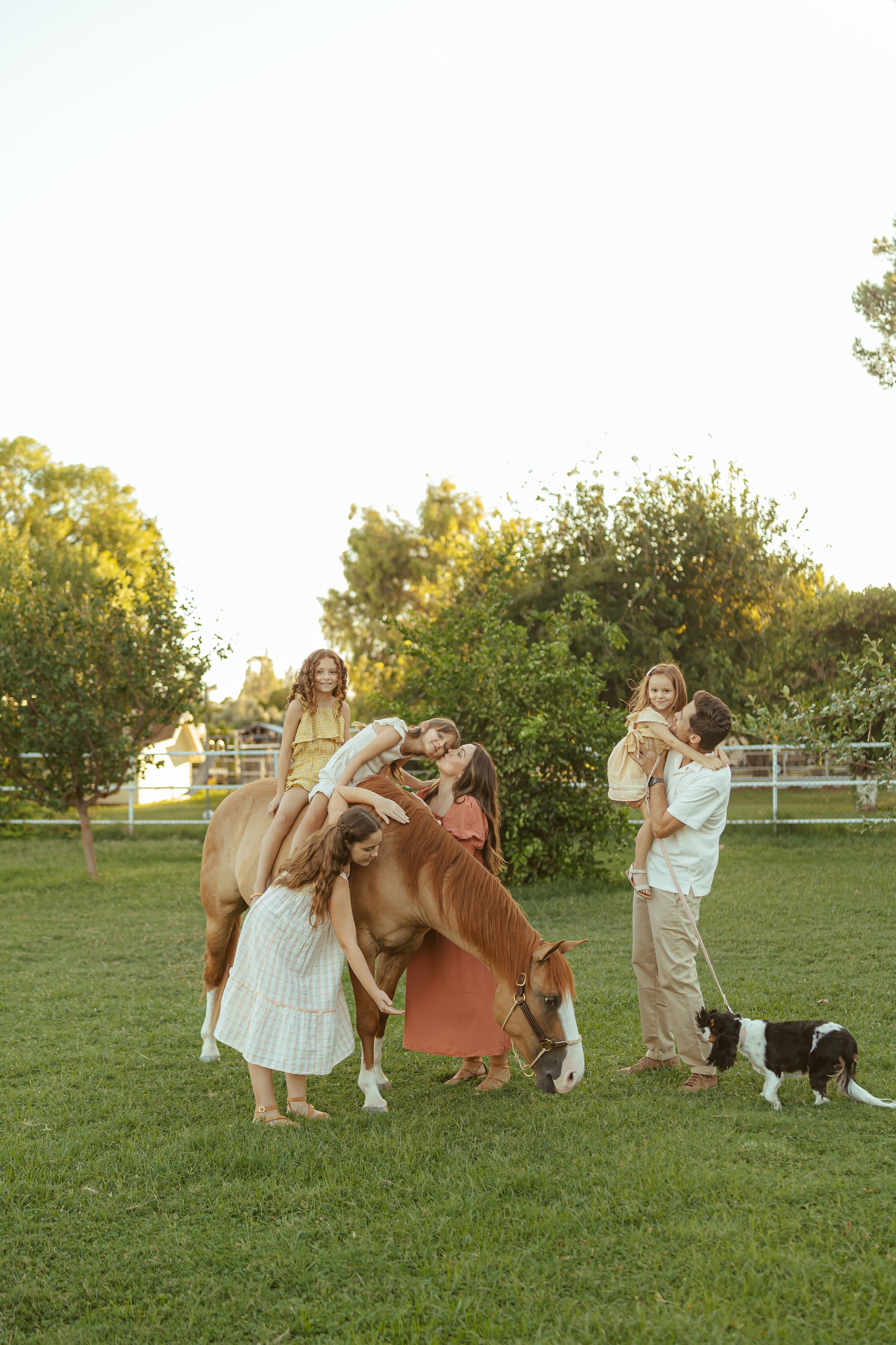 Gilbert family photography at Floyd Family Farms featuring children interacting with their horse and family dog in the golden evening light.