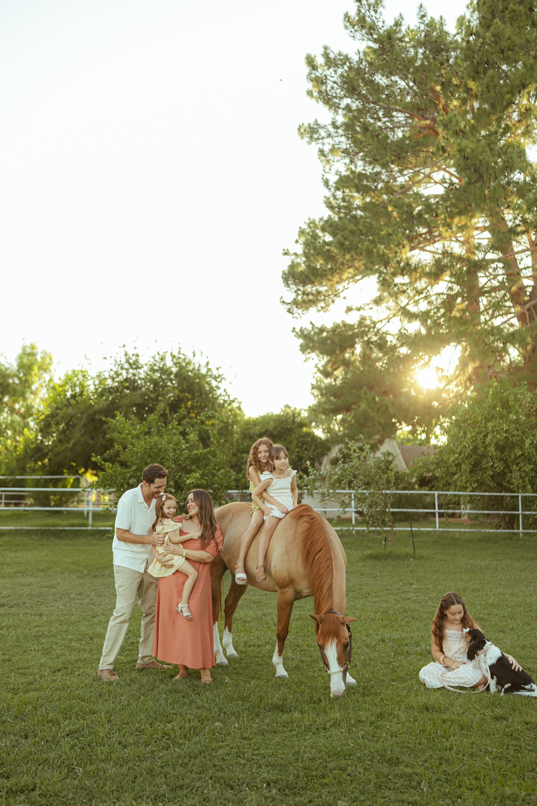 Gilbert family photographer capturing a family portrait with their daughters and horse at Floyd Family Farms during golden hour in Arizona.