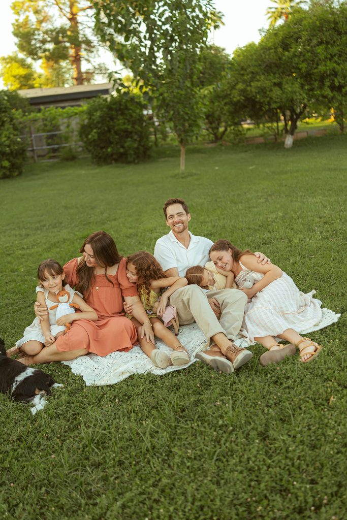 Gilbert family photography featuring parents and children gathered together in the grass with their horse and dog at Floyd Family Farms.