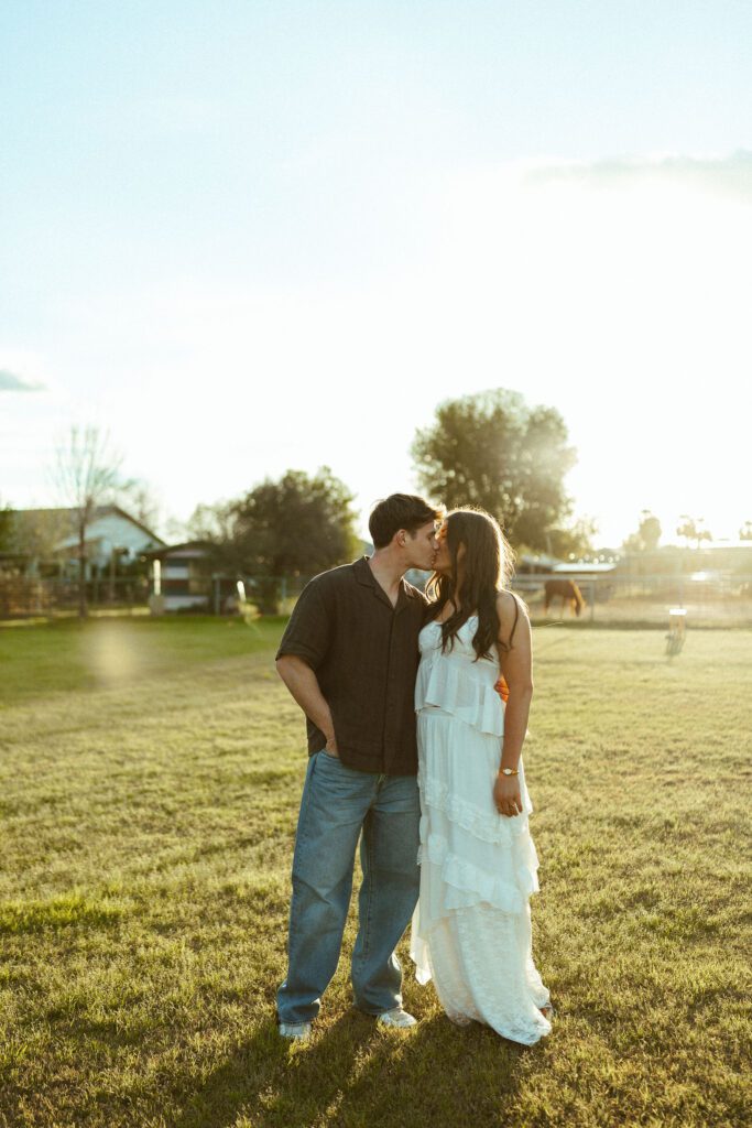 Couple kissing in warm golden hour light during an outdoor couples photography session in Gilbert, Arizona