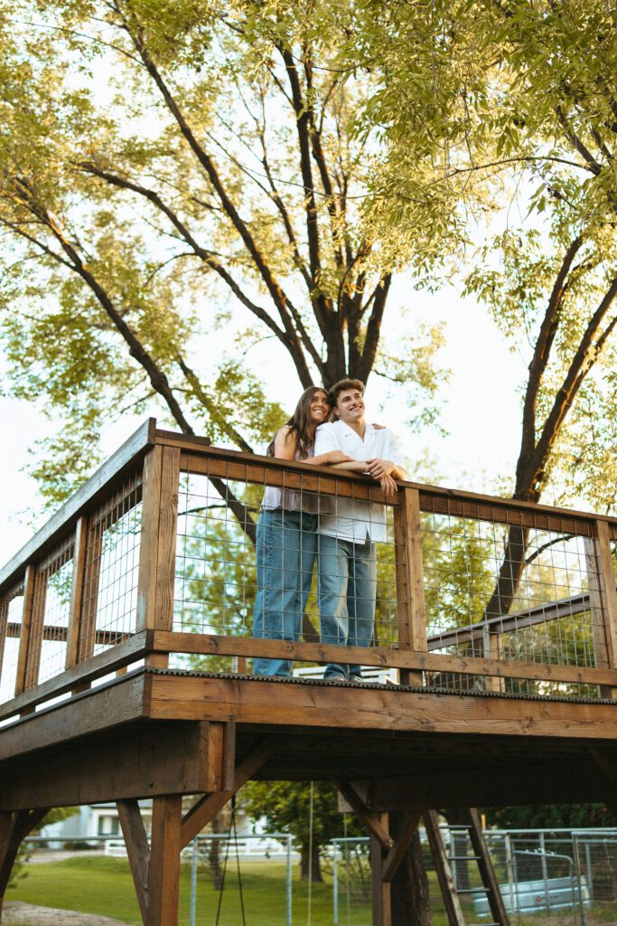 Couple kissing on a wooden deck during a golden hour couples session at The Cozy Acre in Gilbert, AZ