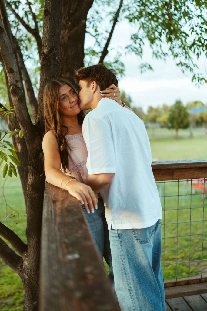 Couple sharing a romantic moment under the trees during an outdoor couples photography session in Gilbert, Arizona