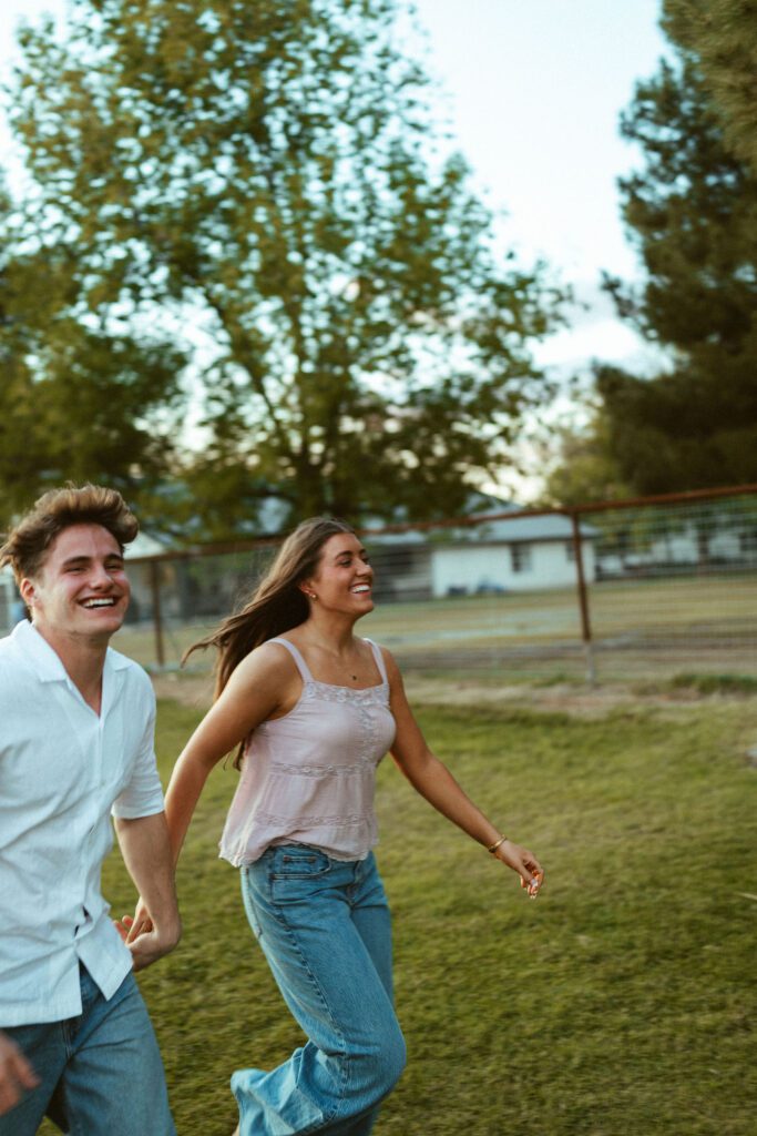 Couple running and laughing together during candid golden hour couples photos in Gilbert, AZ