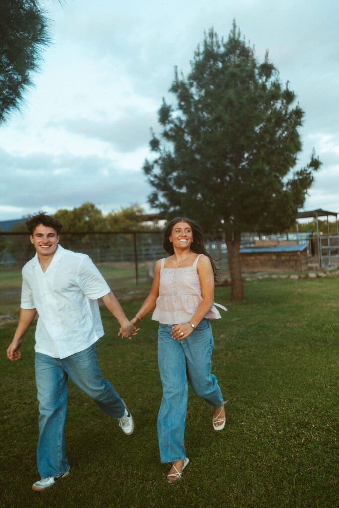 Couple running and laughing together during a playful couples photography session in Gilbert, Arizona