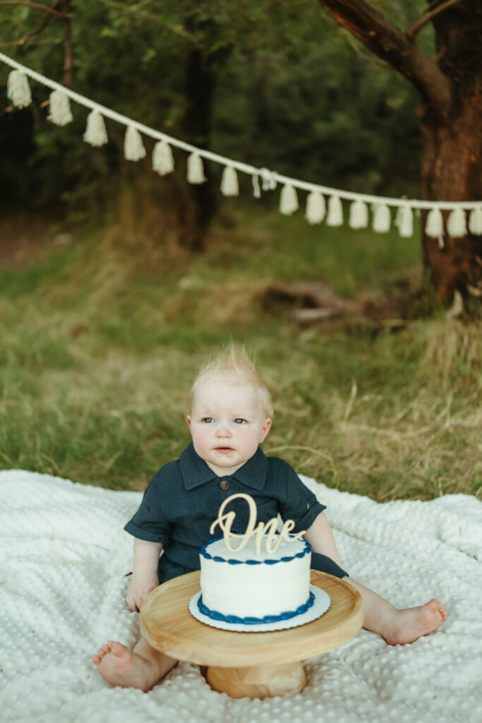 Baby boy celebrating his first birthday with an outdoor cake smash at Butcher Jones near Saguaro Lake in Mesa, Arizona.